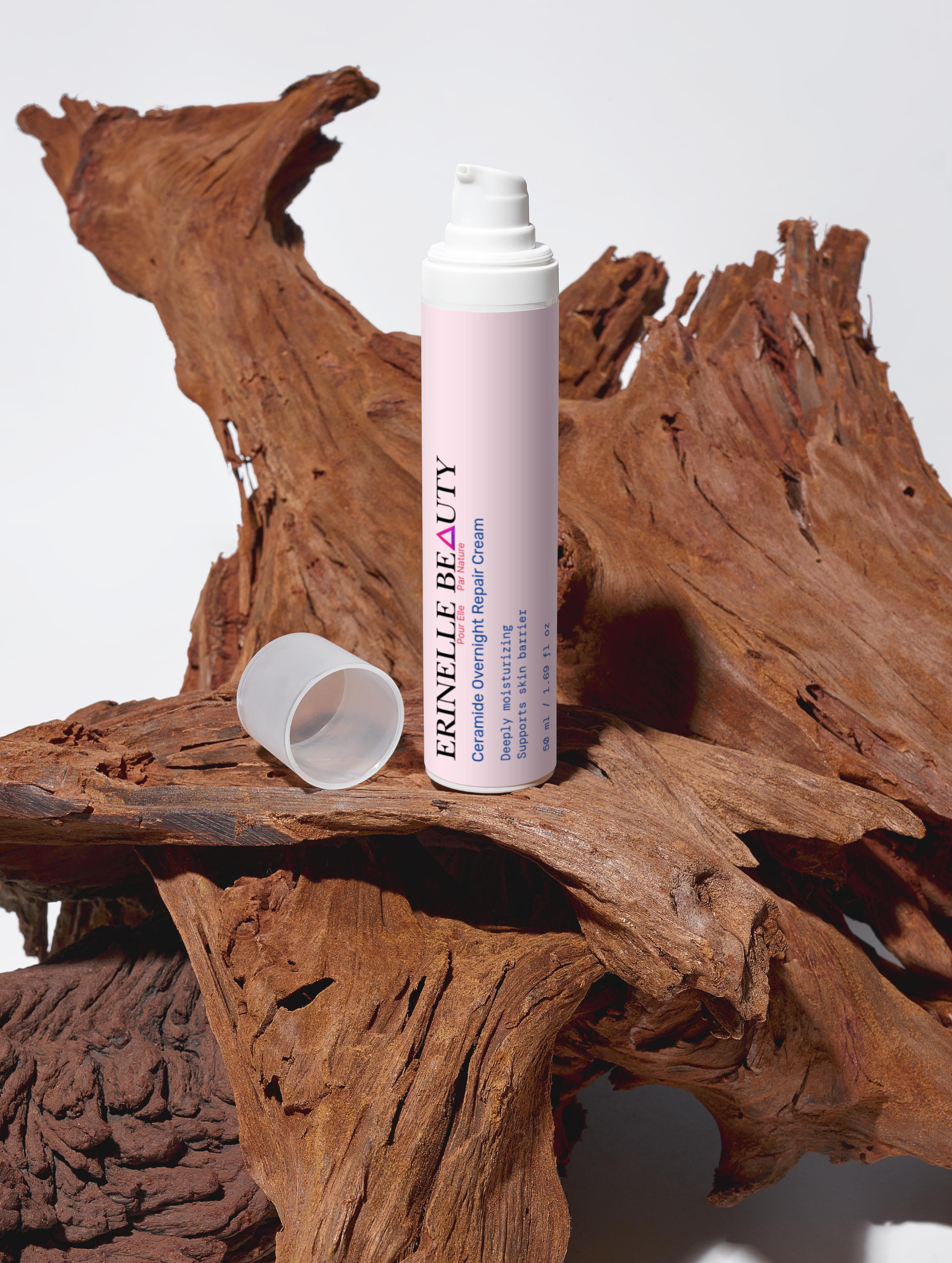 Erinelle Beauty ceramide overnight repair cream in a pink pump bottle on natural wood background